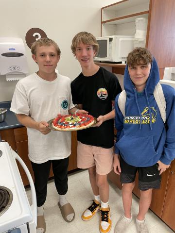 Kids pose with their pizza 