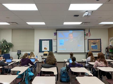 Author Grant Sinder zoomed in to the writing club. The picture shows him on the screen and the class looking on 